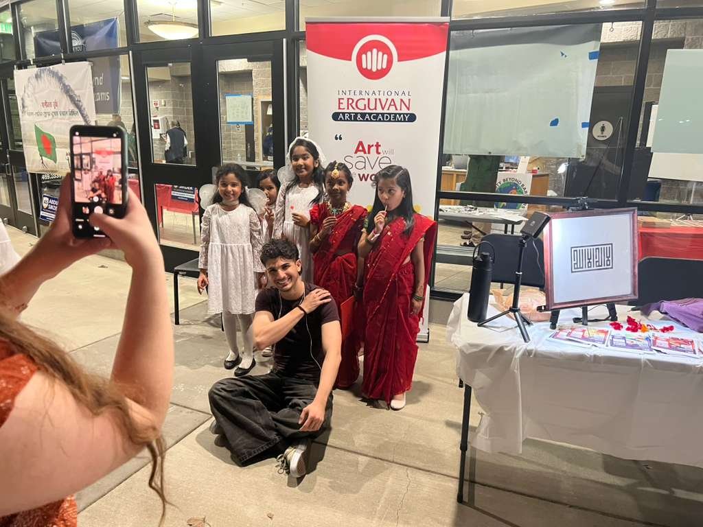 Children in traditional clothing taking a photo with Enes at the HBB Gala